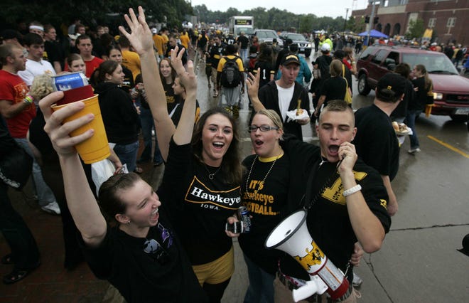 University of Northern Iowa students, but diehard Iowa fans, Emily Herbst, left, Kelly Hess, Amber Wallingford and Wes Hunt, right, use a megaphone to cheer the Hawkeyes in the middle of Melrose Ave. Saturday Sept. 13, 2008, pregame.