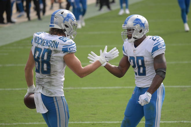 Detroit Lions tight end T.J. Hockenson (88) celebrates his touchdown reception against the Jacksonville Jaguars with running back Adrian Peterson (28) during the second half of an NFL football game, Sunday, Oct. 18, 2020, in Jacksonville, Florida. (AP Photo/Phelan M. Ebenhack)