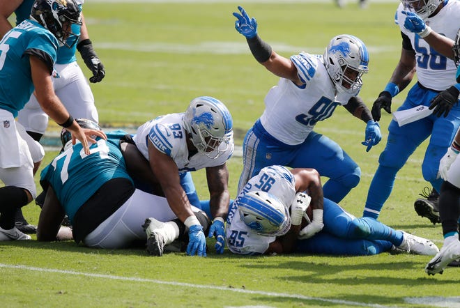 Detroit Lions defensive end Trey Flowers (90) celebrates as Detroit Lions defensive end Romeo Okwara (95) falls on the ball that he stripped from Jacksonville Jaguars quarterback Gardner Minshew II (15) during the second quarter Oct. 18, 2020, at TIAA Bank Field.
