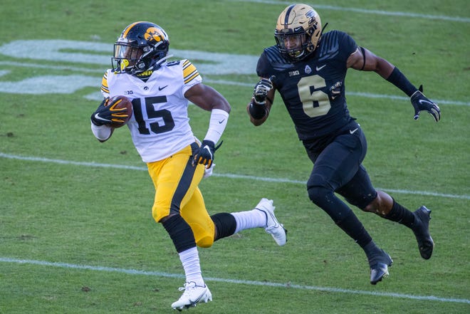 Oct 24, 2020; West Lafayette, Indiana, USA; Iowa Hawkeyes running back Tyler Goodson (15) runs the ball while Purdue Boilermakers safety Jalen Graham (6) defends  in the first quarter at Ross-Ade Stadium. Mandatory Credit: Trevor Ruszkowski-USA TODAY Sports
