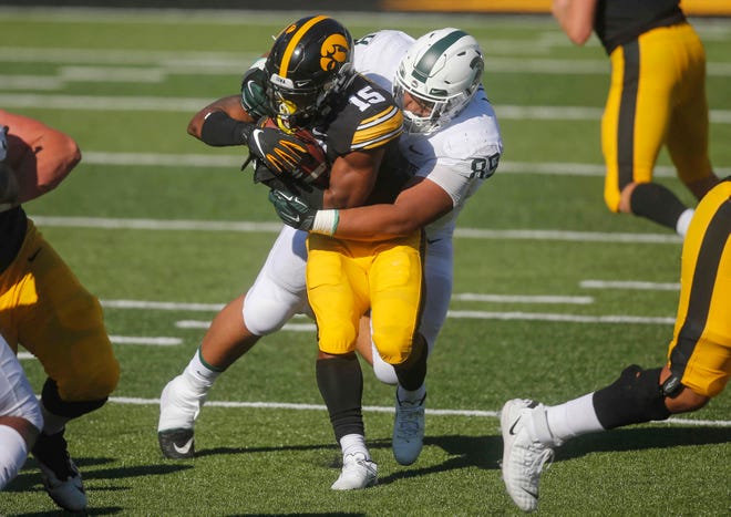 Iowa sophomore running back Tyler Goodson is wrapped up by Michigan State's Jalen Hunt at Kinnick Stadium in Iowa City on Saturday, Nov. 7, 2020.