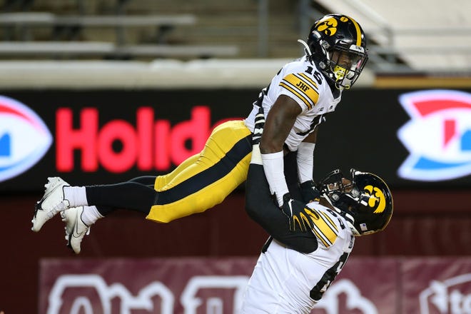 Iowa offensive lineman Justin Britt (63) lifts running back Tyler Goodson (15) in celebration after Goodson scored a touchdown against Minnesota during the first half of an NCAA college football game Friday, Nov. 13, 2020, in Minneapolis. (AP Photo/Stacy Bengs)