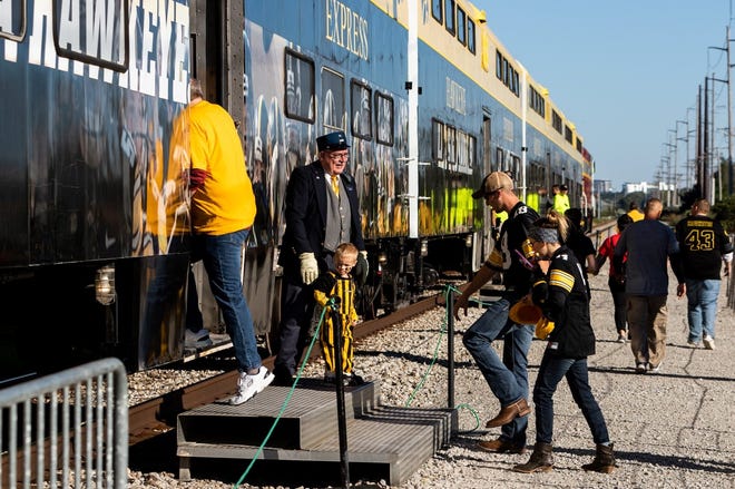 Volunteers like David Kelzenberg of Iowa City, shown here, sometimes in vintage railroad conductor garb, assist fans in every car of the Hawkeye Express. The train, which has been running between Coralville and Kinnick Stadium on football game days since 2004, will no longer be offered.