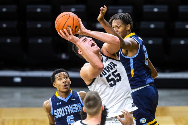 Iowa center Luka Garza (55) gets fouled by Southern University center Harrison Henderson, right, as Jayden Saddler defends during a NCAA non-conference men's basketball game, Friday, Nov. 27, 2020, at Carver-Hawkeye Arena in Iowa City, Iowa.