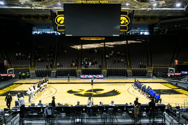 Southern University players and coaches kneel as the national anthem is played while Iowa players stand before a NCAA non-conference men's basketball game, Friday, Nov. 27, 2020, at Carver-Hawkeye Arena in Iowa City, Iowa. Iowa Hawkeyes players knelt prior to the anthem was played.