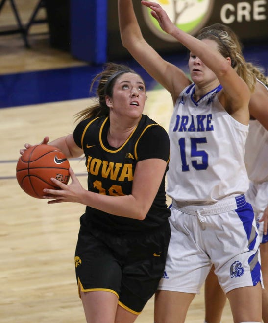 Iowa's McKenna Warnock drives to the basket around Drake's Allie Wooldridge in the second quarter at the Knapp Center in Des Moines on Wednesday, Dec. 2, 2020.