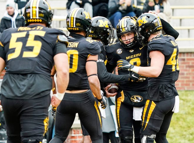 Missouri quarterback Connor Bazelak (8) is congratulated by teammates after scoring a touchdown during a game against Georgia on Dec. 12 at Faurot Field.