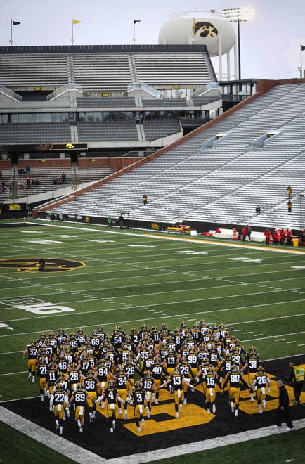 Members of the Iowa Hawkeyes football team take the field to an empty stadium prior to kickoff against Wisconsin on Saturday, Dec. 12, 2020, at Kinnick Stadium in Iowa City, Iowa.