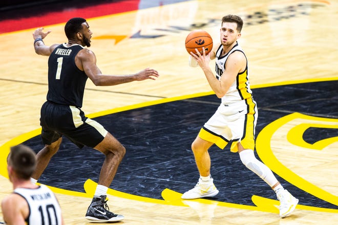 Iowa guard Jordan Bohannon, right, looks to pass as Purdue forward Aaron Wheeler (1) defends during a NCAA Big Ten Conference men's basketball game, Tuesday, Dec. 22, 2020, at Carver-Hawkeye Arena in Iowa City, Iowa.
