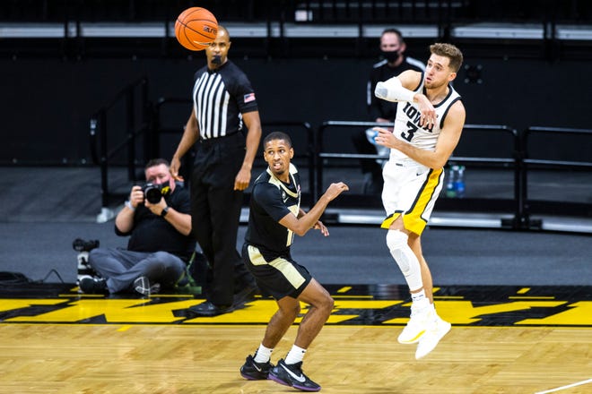 Iowa guard Jordan Bohannon (3) throws a pass out to a teammate as Purdue guard Isaiah Thompson defends during a NCAA Big Ten Conference men's basketball game, Tuesday, Dec. 22, 2020, at Carver-Hawkeye Arena in Iowa City, Iowa.