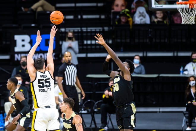 Iowa center Luka Garza (55) makes a 3-point basket as Purdue forward Trevion Williams (50) defends during a NCAA Big Ten Conference men's basketball game, Tuesday, Dec. 22, 2020, at Carver-Hawkeye Arena in Iowa City, Iowa.
