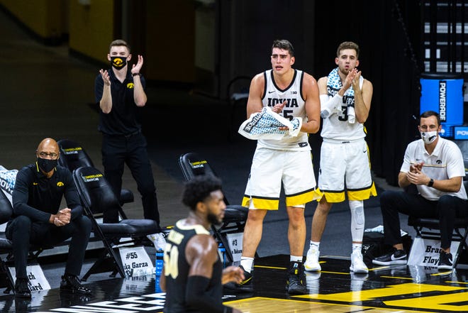 Iowa center Luka Garza (55) and Iowa guard Jordan Bohannon (3) cheer on teammates from the bench during a NCAA Big Ten Conference men's basketball game, Tuesday, Dec. 22, 2020, at Carver-Hawkeye Arena in Iowa City, Iowa.
