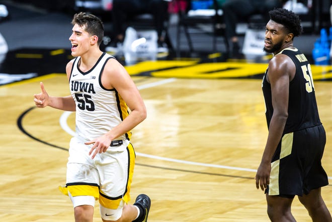 Iowa center Luka Garza (55) celebrates after making a 3-point basket as Purdue forward Trevion Williams (50) defends during a NCAA Big Ten Conference men's basketball game, Tuesday, Dec. 22, 2020, at Carver-Hawkeye Arena in Iowa City, Iowa.