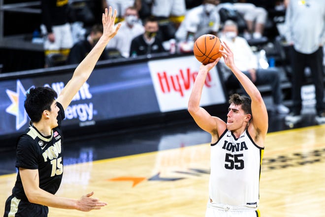Iowa center Luka Garza (55) makes a 3-point basket as Purdue center Zach Edey (15) defends during a NCAA Big Ten Conference men's basketball game, Tuesday, Dec. 22, 2020, at Carver-Hawkeye Arena in Iowa City, Iowa.