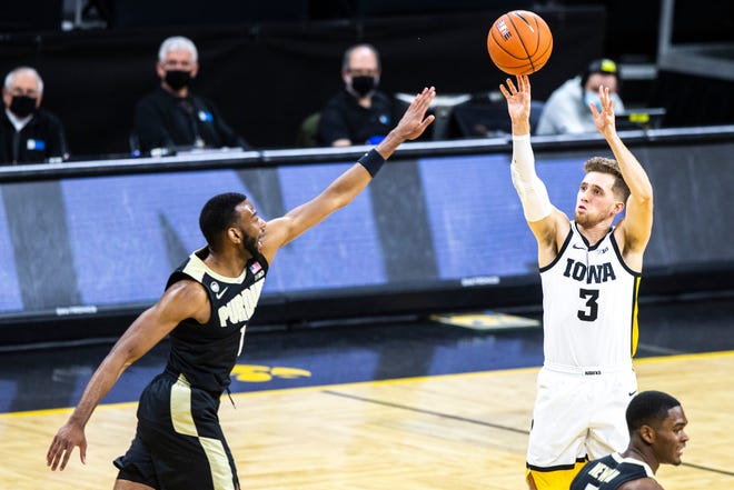 Iowa guard Jordan Bohannon (3) makes a 3-point basket as Purdue forward Aaron Wheeler (1) defends during a NCAA Big Ten Conference men's basketball game, Tuesday, Dec. 22, 2020, at Carver-Hawkeye Arena in Iowa City, Iowa.