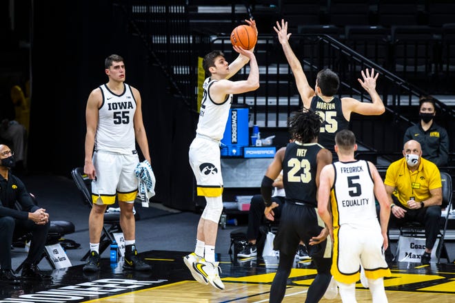 Iowa forward Patrick McCaffery (22) makes a 3-point basket as Purdue guard Ethan Morton (25) defends during a NCAA Big Ten Conference men's basketball game, Tuesday, Dec. 22, 2020, at Carver-Hawkeye Arena in Iowa City, Iowa.