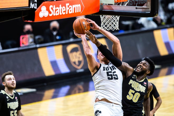 Iowa center Luka Garza (55) gets fouled by Purdue forward Trevion Williams (50) during a NCAA Big Ten Conference men's basketball game, Tuesday, Dec. 22, 2020, at Carver-Hawkeye Arena in Iowa City, Iowa.