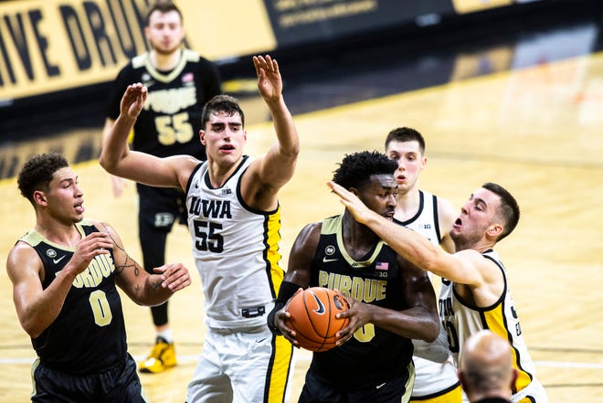 Purdue forward Trevion Williams (50) pulls down a rebound against Iowa's Connor McCaffery, right, as Purdue forward Mason Gillis (0) Iowa center Luka Garza (55) and Iowa guard CJ Fredrick, back, look on during a NCAA Big Ten Conference men's basketball game, Tuesday, Dec. 22, 2020, at Carver-Hawkeye Arena in Iowa City, Iowa.
