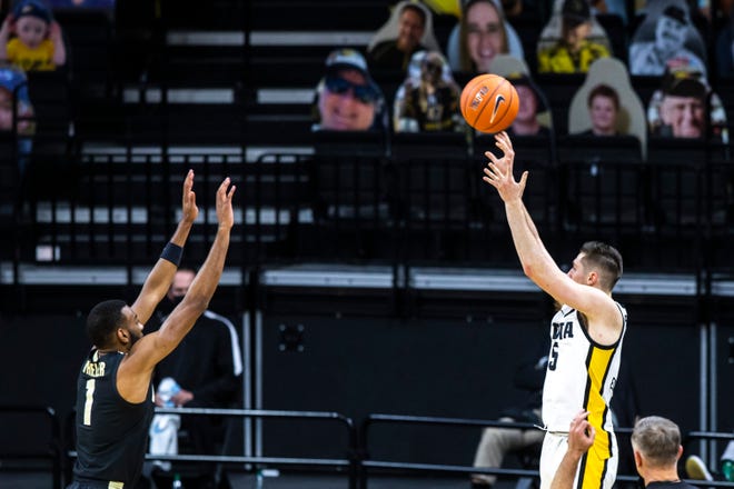Iowa guard CJ Fredrick (5) makes a 3-point basket as Purdue forward Aaron Wheeler (1) defends during a NCAA Big Ten Conference men's basketball game, Tuesday, Dec. 22, 2020, at Carver-Hawkeye Arena in Iowa City, Iowa.