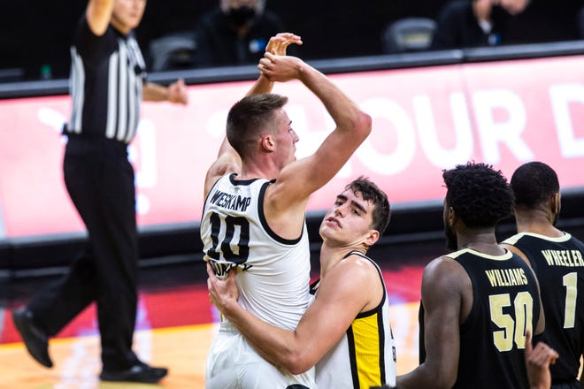 Iowa center Luka Garza catches Iowa's Joe Wieskamp (10) as he comes off the rim while getting fouled on an attempted dunk during a NCAA Big Ten Conference men's basketball game against Purdue, Tuesday, Dec. 22, 2020, at Carver-Hawkeye Arena in Iowa City, Iowa.