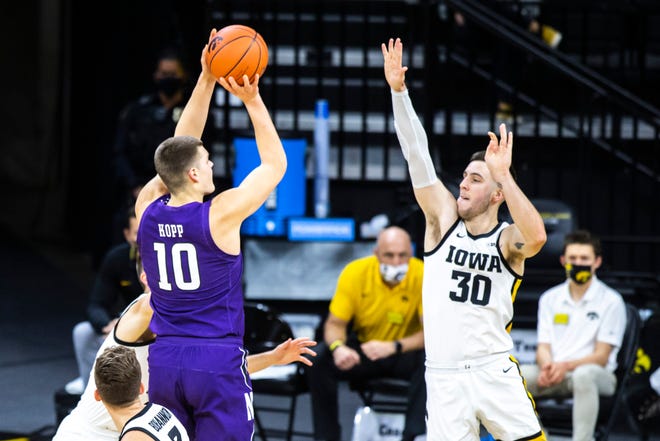 Northwestern forward Miller Kopp (10) makes a basket as Iowa's Connor McCaffery (30) defends during a NCAA Big Ten Conference men's basketball game, Tuesday, Dec. 29, 2020, at Carver-Hawkeye Arena in Iowa City, Iowa.