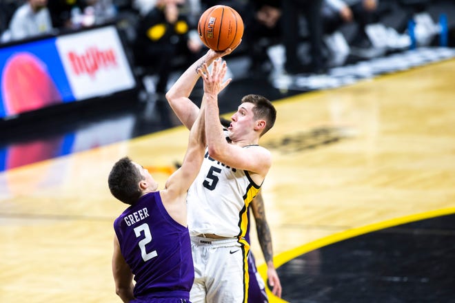Iowa guard CJ Fredrick (5) makes a basket as Northwestern guard Ryan Greer (2) defends during a NCAA Big Ten Conference men's basketball game, Tuesday, Dec. 29, 2020, at Carver-Hawkeye Arena in Iowa City, Iowa.