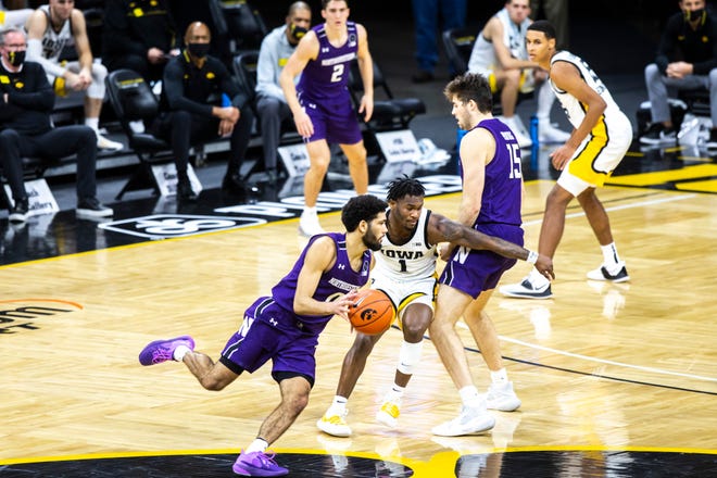 Iowa guard Joe Toussaint (1) defends Northwestern guard Boo Buie (0) during a NCAA Big Ten Conference men's basketball game, Tuesday, Dec. 29, 2020, at Carver-Hawkeye Arena in Iowa City, Iowa.