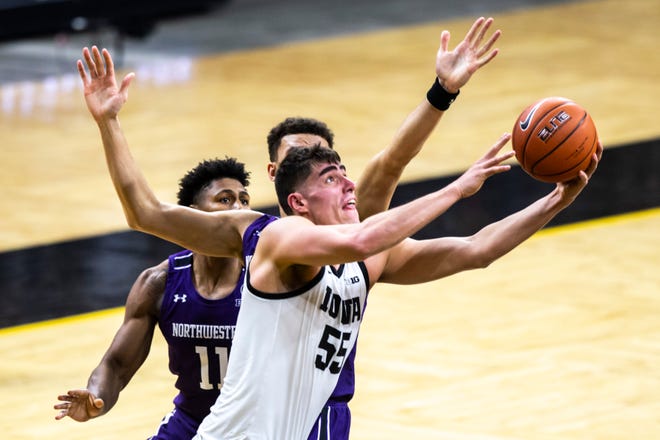 Iowa center Luka Garza (55) gets fouled by Northwestern forward Pete Nance, behind, during a NCAA Big Ten Conference men's basketball game, Tuesday, Dec. 29, 2020, at Carver-Hawkeye Arena in Iowa City, Iowa.