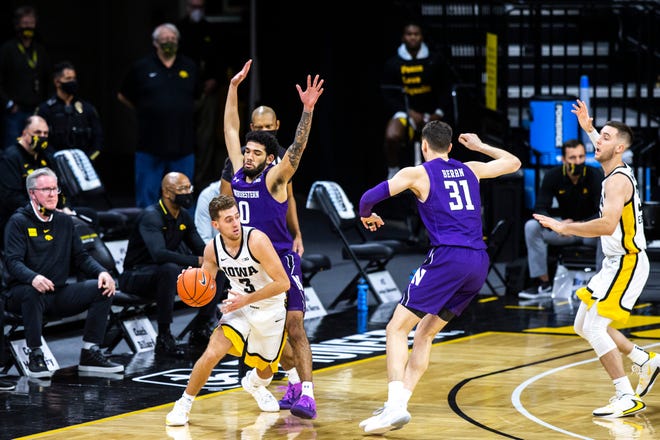 Iowa guard Jordan Bohannon (3) dribbles as Northwestern guard Boo Buie (0) defends during a NCAA Big Ten Conference men's basketball game, Tuesday, Dec. 29, 2020, at Carver-Hawkeye Arena in Iowa City, Iowa.