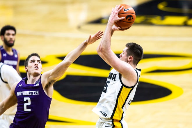 Iowa guard CJ Fredrick, right, makes a basket as Northwestern guard Ryan Greer (2) defends as the end of the first half during a NCAA Big Ten Conference men's basketball game, Tuesday, Dec. 29, 2020, at Carver-Hawkeye Arena in Iowa City, Iowa.