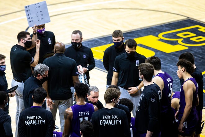 Northwestern head coach Chris Collins talks with players in a timeout during a NCAA Big Ten Conference men's basketball game, Tuesday, Dec. 29, 2020, at Carver-Hawkeye Arena in Iowa City, Iowa.