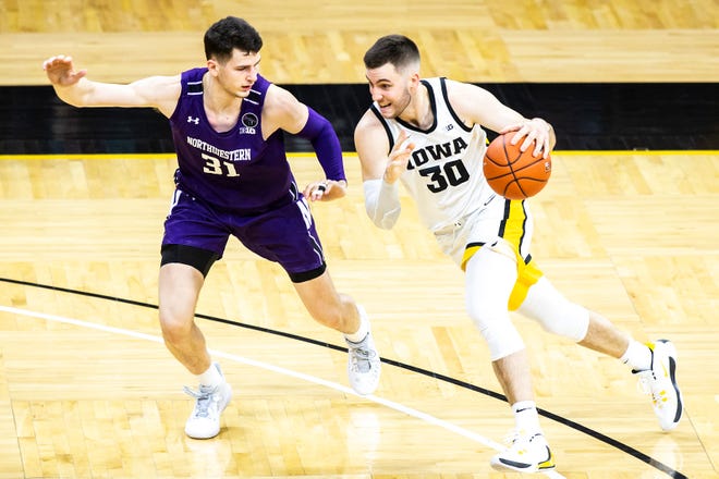Iowa's Connor McCaffery (30) drives to the basket against Northwestern forward Robbie Beran (31) during a NCAA Big Ten Conference men's basketball game, Tuesday, Dec. 29, 2020, at Carver-Hawkeye Arena in Iowa City, Iowa.