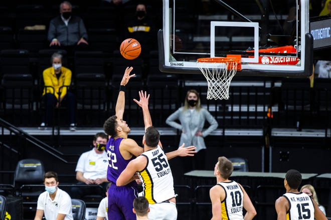 Northwestern forward Pete Nance (22) makes a basket as Iowa center Luka Garza (55) defends during a NCAA Big Ten Conference men's basketball game, Tuesday, Dec. 29, 2020, at Carver-Hawkeye Arena in Iowa City, Iowa.