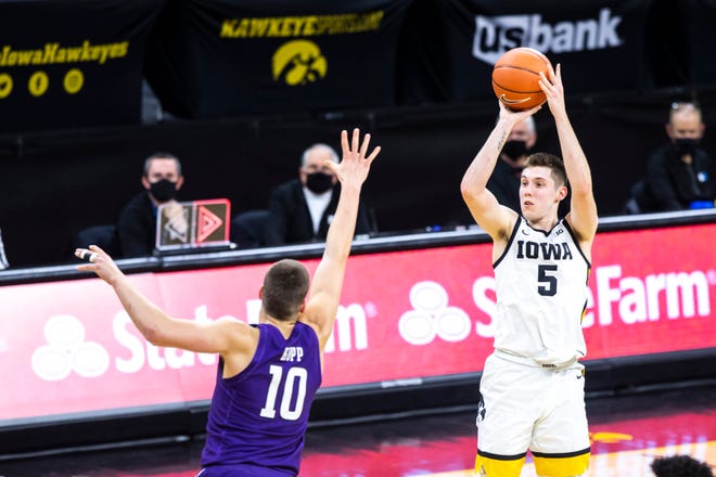 Iowa guard CJ Fredrick (5) makes a 3-point basket as Northwestern forward Miller Kopp (10) defends during a NCAA Big Ten Conference men's basketball game, Tuesday, Dec. 29, 2020, at Carver-Hawkeye Arena in Iowa City, Iowa.