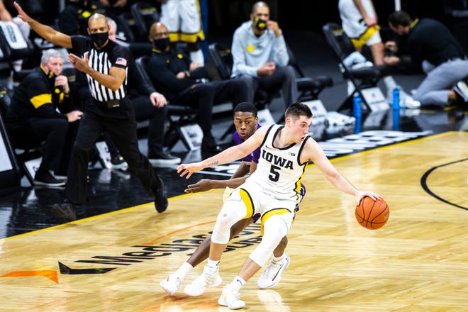 Iowa guard CJ Fredrick (5) catches a loose ball as Northwestern guard Chase Audige (1) defends during a NCAA Big Ten Conference men's basketball game, Tuesday, Dec. 29, 2020, at Carver-Hawkeye Arena in Iowa City, Iowa.