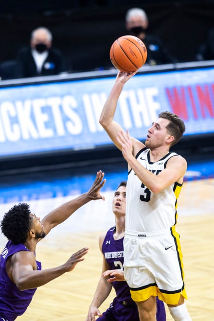 Iowa guard Jordan Bohannon (3) makes a basket as Northwestern guards Anthony Gaines, left, and Ryan Greer defend during a NCAA Big Ten Conference men's basketball game, Tuesday, Dec. 29, 2020, at Carver-Hawkeye Arena in Iowa City, Iowa.