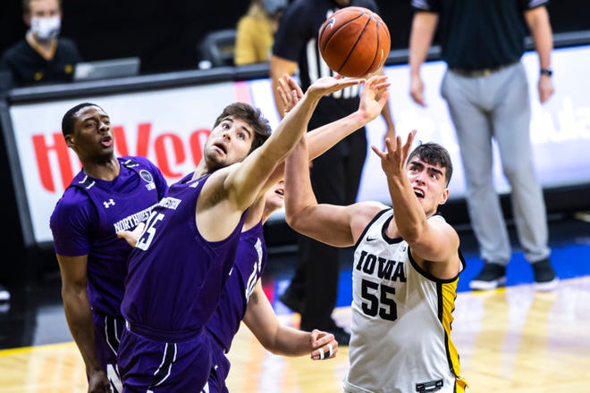 Iowa center Luka Garza (55) grabs a rebound against Northwestern center Ryan Young, left, during a NCAA Big Ten Conference men's basketball game, Tuesday, Dec. 29, 2020, at Carver-Hawkeye Arena in Iowa City, Iowa.
