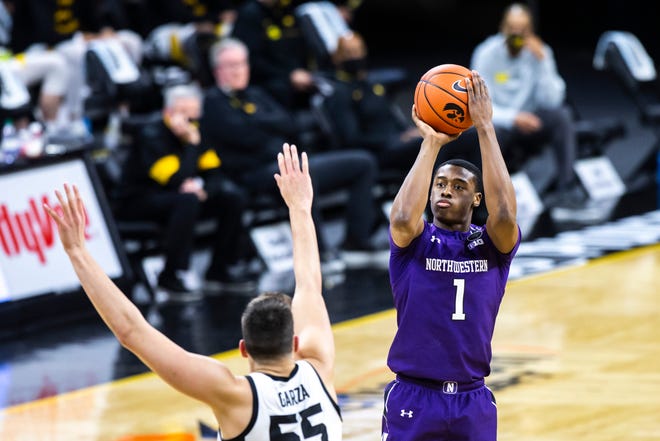 Northwestern guard Chase Audige (1) makes a 3-point basket as Iowa center Luka Garza (55) defends during a NCAA Big Ten Conference men's basketball game, Tuesday, Dec. 29, 2020, at Carver-Hawkeye Arena in Iowa City, Iowa.