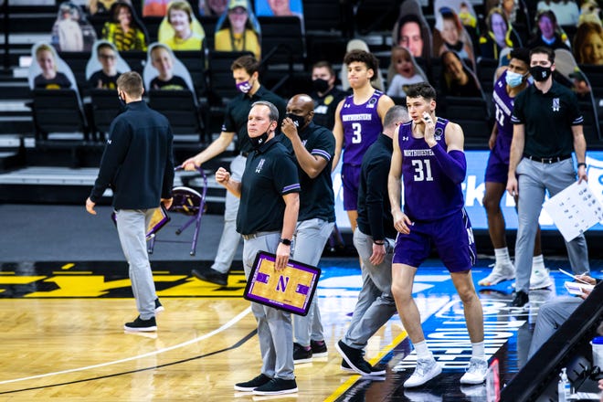Northwestern head coach Chris Collins holds a clipboard heading into a timeout during a NCAA Big Ten Conference men's basketball game, Tuesday, Dec. 29, 2020, at Carver-Hawkeye Arena in Iowa City, Iowa.