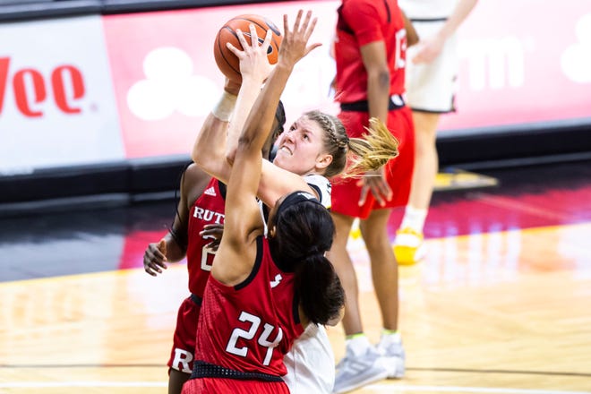 Iowa center Monika Czinano (25) gets fouled by Rutgers guard Arella Guirantes (24) during a NCAA Big Ten Conference women's basketball game, Thursday, Dec. 31, 2020, at Carver-Hawkeye Arena in Iowa City, Iowa.