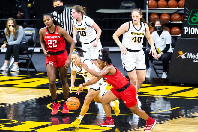 Iowa guard Alexis Sevillian battles Rutgers guard Diamond Johnson for a loose ball during a NCAA Big Ten Conference women's basketball game, Thursday, Dec. 31, 2020, at Carver-Hawkeye Arena in Iowa City, Iowa.