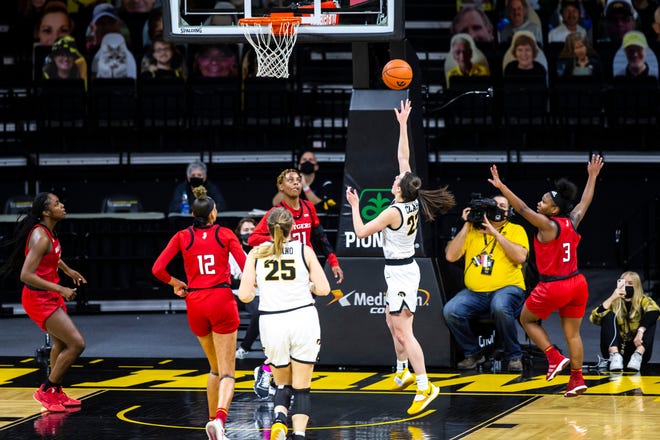 Iowa guard Caitlin Clark (22) makes a basket as Rutgers's Tekia Mack (31) and Rutgers guard Diamond Johnson (3) defend during a NCAA Big Ten Conference women's basketball game, Thursday, Dec. 31, 2020, at Carver-Hawkeye Arena in Iowa City, Iowa.