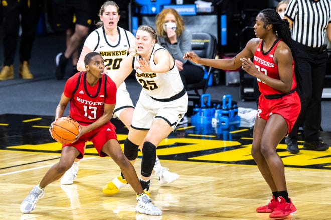 Rutgers forward Mael Gilles (13) looks to pass as Iowa center Monika Czinano (25) defends during a NCAA Big Ten Conference women's basketball game, Thursday, Dec. 31, 2020, at Carver-Hawkeye Arena in Iowa City, Iowa.