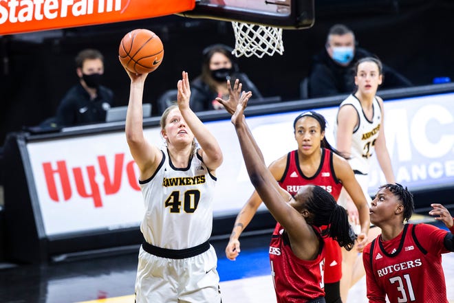 Iowa center Sharon Goodman (40) makes a basket as Rutgers forward Chyna Cornwell and Tekia Mack (31) defend during a NCAA Big Ten Conference women's basketball game, Thursday, Dec. 31, 2020, at Carver-Hawkeye Arena in Iowa City, Iowa.