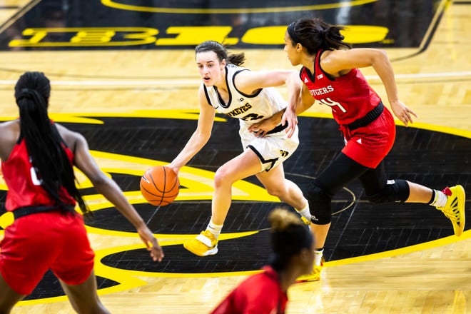 Iowa guard Caitlin Clark, left, dribbles as Rutgers guard Arella Guirantes defends during a NCAA Big Ten Conference women's basketball game, Thursday, Dec. 31, 2020, at Carver-Hawkeye Arena in Iowa City, Iowa.