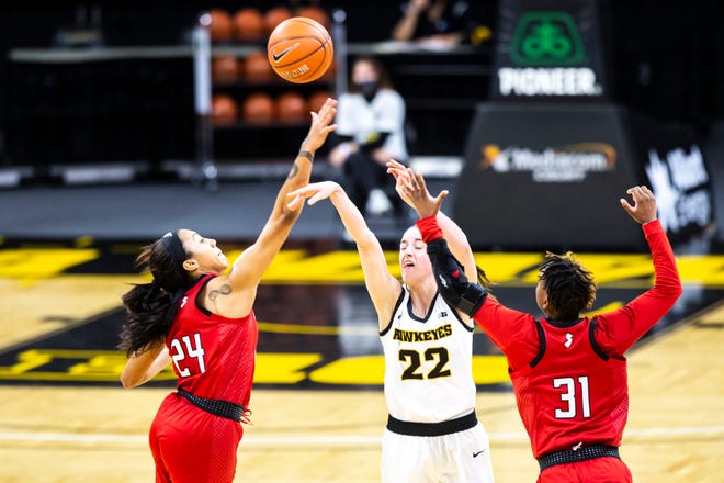 Iowa guard Caitlin Clark (22) attempts to shoot a 3-point basket at the end of the first half as Rutgers guard Arella Guirantes (24) and Rutgers's Tekia Mack (31) defend during a NCAA Big Ten Conference women's basketball game, Thursday, Dec. 31, 2020, at Carver-Hawkeye Arena in Iowa City, Iowa.