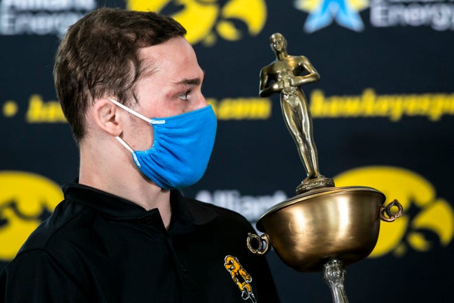 Iowa 125-pound wrestler Spencer Lee, left, is presented with the 2020 Dan Hodge Trophy during Hawkeyes wrestling media day, Tuesday, Jan. 5, 2021, at the McCord Club level of Kinnick Stadium in Iowa City, Iowa.