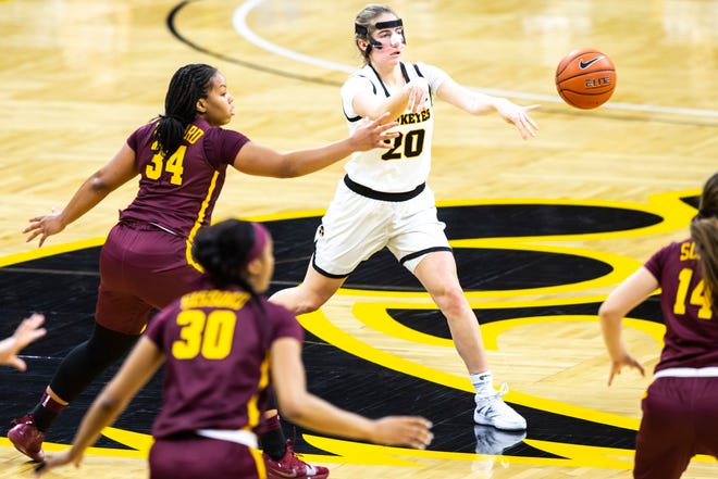 Iowa guard Kate Martin (20) passes to a teammate as Minnesota guard Gadiva Hubbard (34) defends during a NCAA Big Ten Conference women's basketball game, Wednesday, Jan. 6, 2021, at Carver-Hawkeye Arena in Iowa City, Iowa.