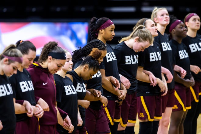 Minnesota Golden Gophers players wear, "BLM" shirts while they link arms as the national anthem is played before a NCAA Big Ten Conference women's basketball game, Wednesday, Jan. 6, 2021, at Carver-Hawkeye Arena in Iowa City, Iowa.