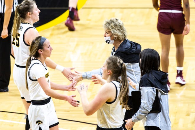 Iowa head coach Lisa Bluder high-fives Iowa center Monika Czinano (25) and Iowa guard Megan Meyer, second from left, heading into a timeout during a NCAA Big Ten Conference women's basketball game against Minnesota, Wednesday, Jan. 6, 2021, at Carver-Hawkeye Arena in Iowa City, Iowa.